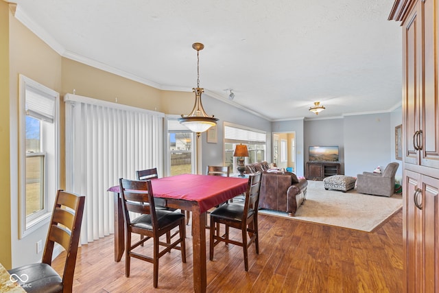 dining area with crown molding and light hardwood / wood-style floors