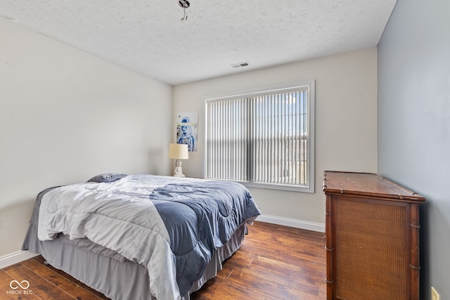 bedroom featuring dark wood-type flooring and a textured ceiling