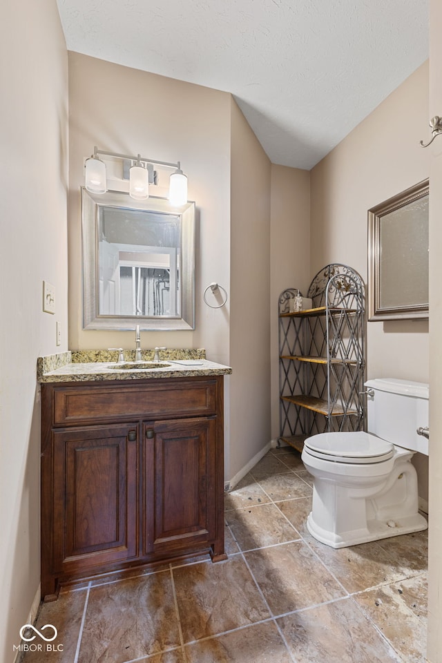 bathroom with vanity, a textured ceiling, and toilet