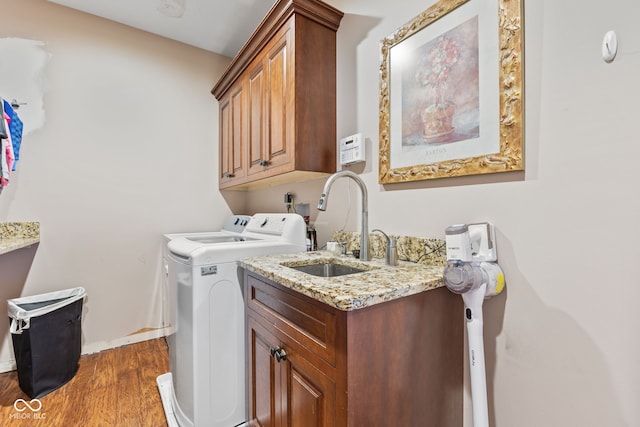 laundry area featuring cabinets, dark hardwood / wood-style flooring, separate washer and dryer, and sink