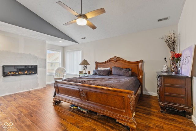 bedroom with vaulted ceiling, dark hardwood / wood-style floors, and ceiling fan