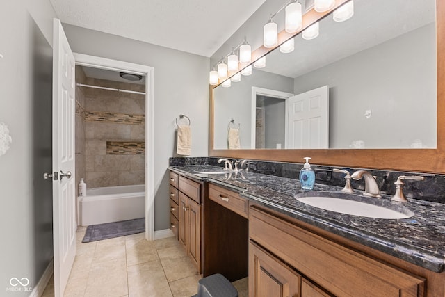 bathroom with vanity, tiled shower / bath combo, tile patterned floors, and a textured ceiling