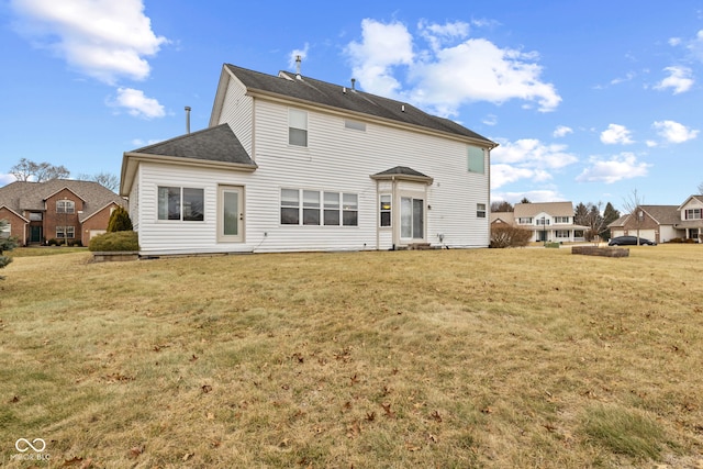 rear view of property featuring a lawn