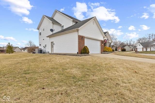 view of side of property with cooling unit, a yard, and a garage