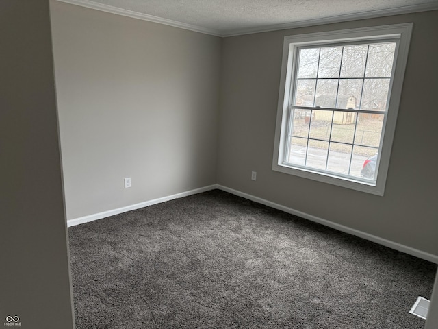 unfurnished room with a wealth of natural light, ornamental molding, a textured ceiling, and dark colored carpet