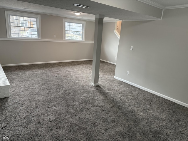 basement with crown molding, a textured ceiling, and dark colored carpet