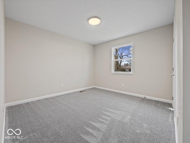 carpeted spare room featuring a textured ceiling