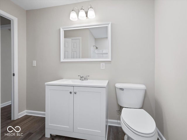 bathroom with wood-type flooring, vanity, and toilet