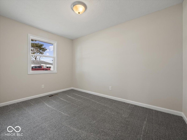 spare room featuring carpet and a textured ceiling