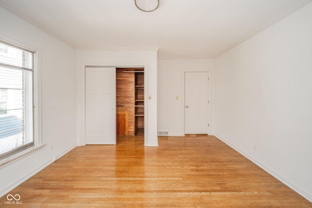 spare room with ornamental molding and light hardwood / wood-style flooring