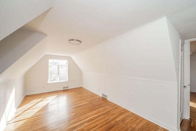 bonus room with vaulted ceiling and light hardwood / wood-style flooring