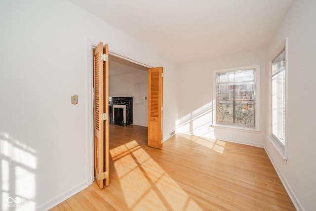 unfurnished room featuring hardwood / wood-style flooring and a high end fireplace