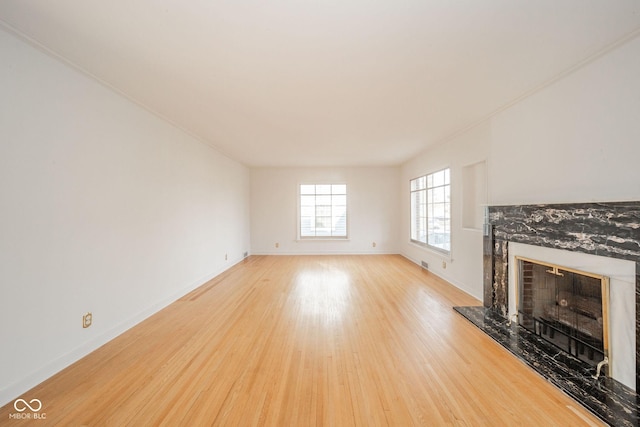 unfurnished living room with a premium fireplace and light hardwood / wood-style floors