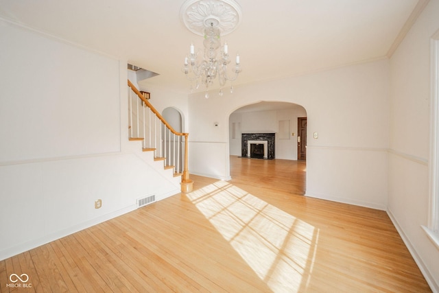 interior space with hardwood / wood-style flooring, crown molding, and a notable chandelier