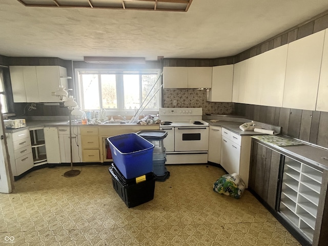 kitchen with double oven range, white cabinets, and backsplash