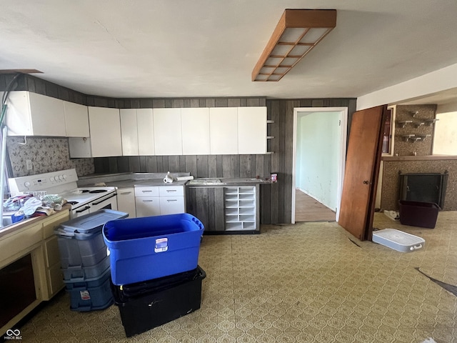 kitchen featuring white cabinetry and electric range