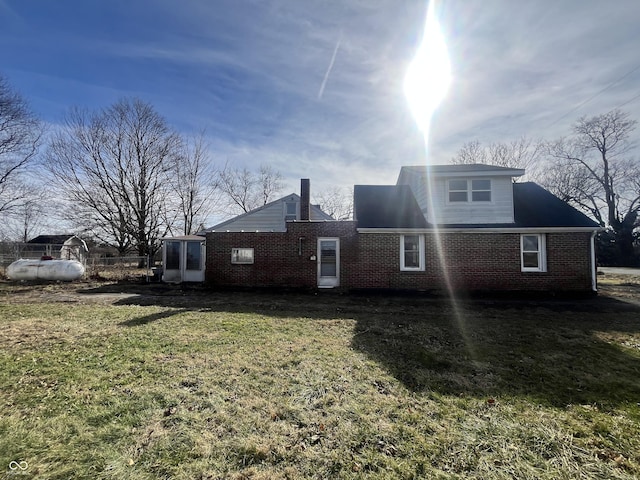 rear view of property featuring a lawn