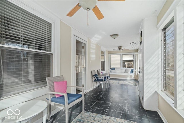 sunroom / solarium featuring ceiling fan