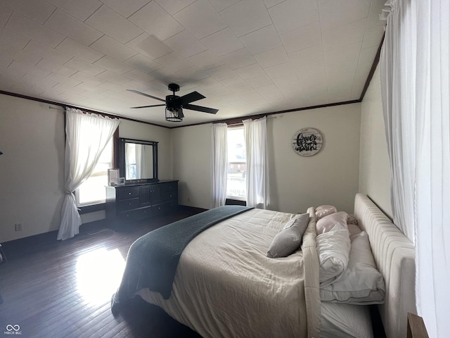 bedroom with hardwood / wood-style floors, ceiling fan, and ornamental molding