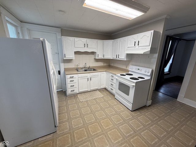 kitchen featuring white range with electric stovetop, stainless steel refrigerator, ornamental molding, sink, and white cabinetry