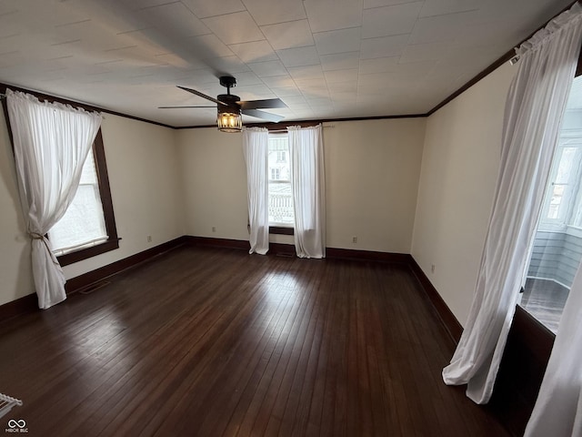 spare room featuring ornamental molding, dark wood-type flooring, and ceiling fan