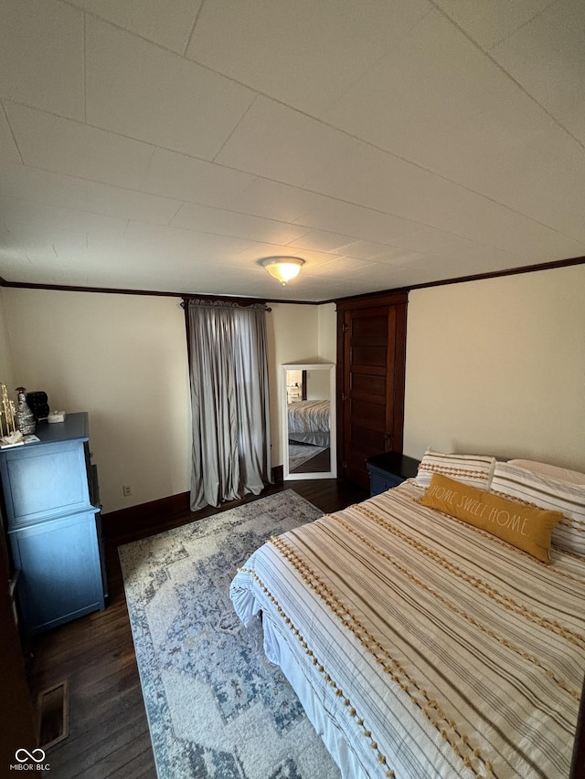 bedroom featuring dark hardwood / wood-style floors and ornamental molding