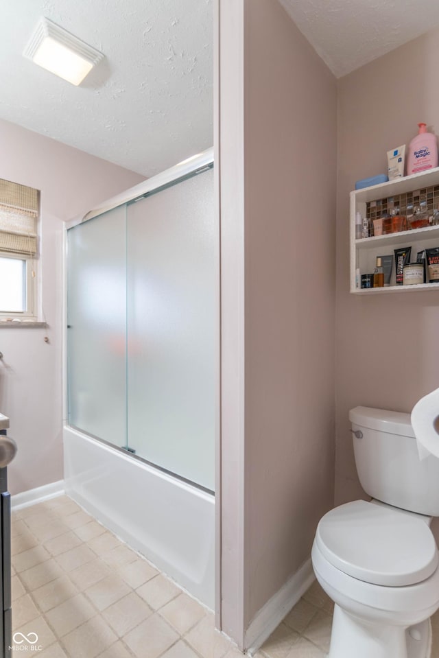 bathroom featuring combined bath / shower with glass door, a textured ceiling, and toilet