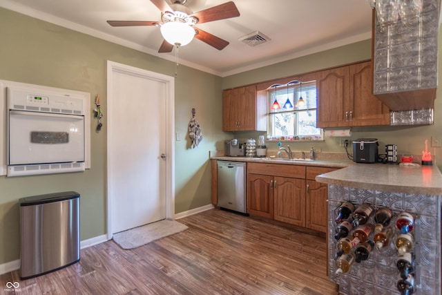 kitchen with sink, crown molding, dishwasher, white oven, and light hardwood / wood-style floors