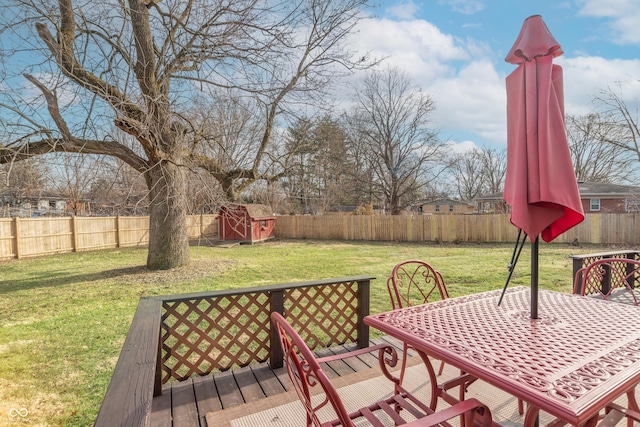 wooden deck with a shed and a lawn