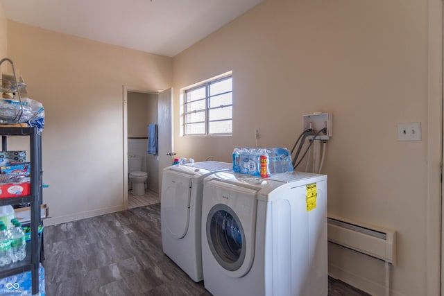 clothes washing area with dark hardwood / wood-style flooring, a baseboard heating unit, and washer and dryer