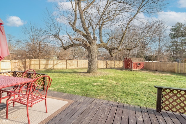 wooden terrace featuring a yard and a storage unit