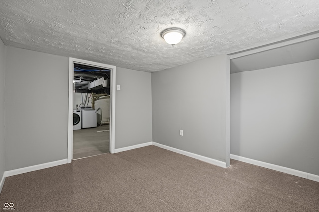 basement with carpet floors, a textured ceiling, and independent washer and dryer