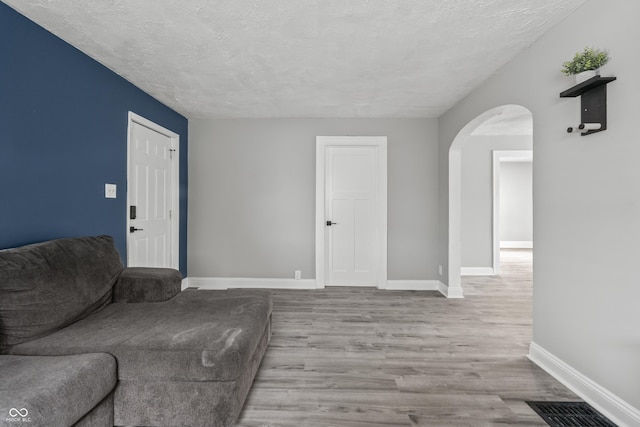 living room featuring a textured ceiling and light wood-type flooring