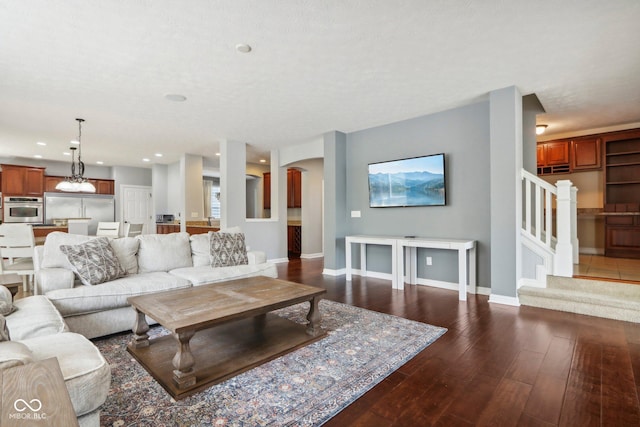 living room featuring dark wood-type flooring and a textured ceiling