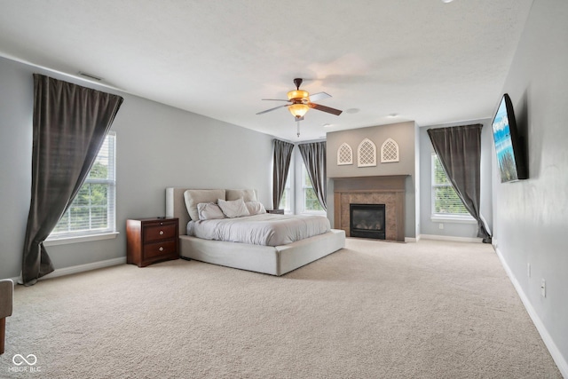 carpeted bedroom with multiple windows and ceiling fan