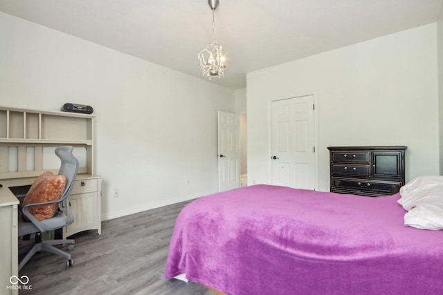 bedroom with hardwood / wood-style floors and a notable chandelier