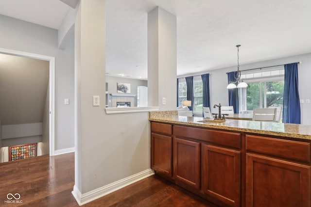 kitchen featuring light stone counters, dark hardwood / wood-style flooring, and sink