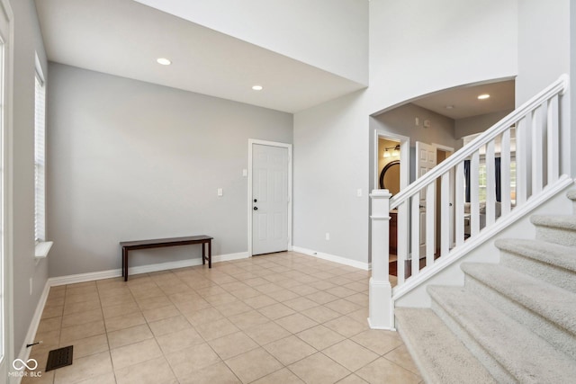 tiled foyer with a towering ceiling