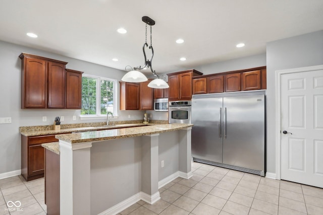 kitchen featuring light stone counters, light tile patterned floors, appliances with stainless steel finishes, a kitchen island, and pendant lighting