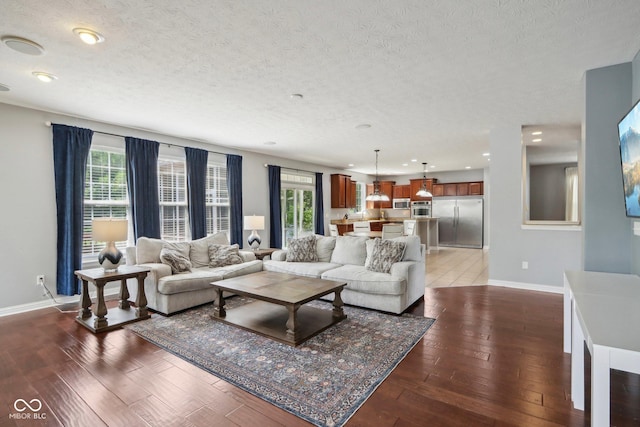 living room with dark hardwood / wood-style flooring and a textured ceiling