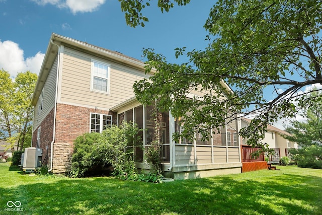 rear view of property with a sunroom and a lawn