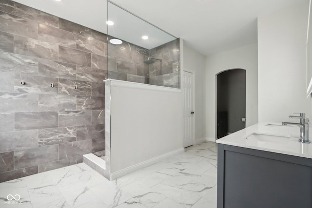 bathroom with a shower, tile walls, and vanity