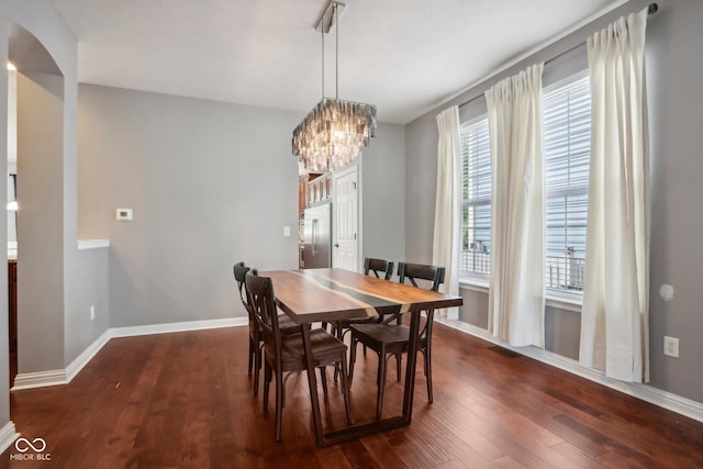 dining room with dark hardwood / wood-style floors and a chandelier