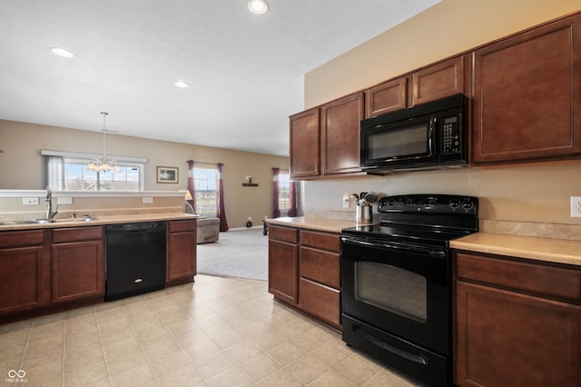 kitchen with sink, pendant lighting, a chandelier, and black appliances