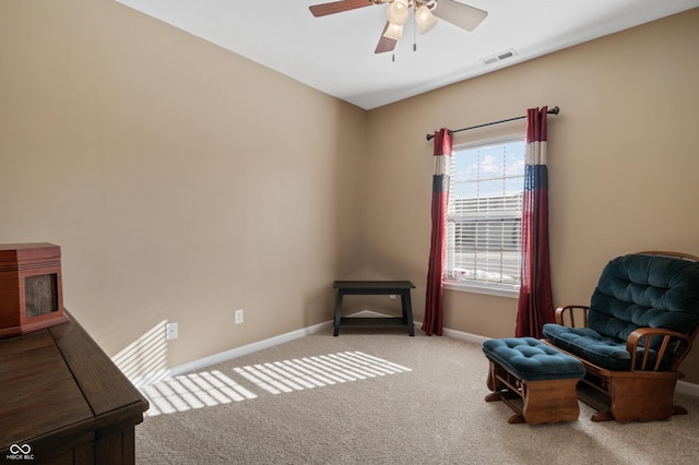 living area with light carpet and ceiling fan