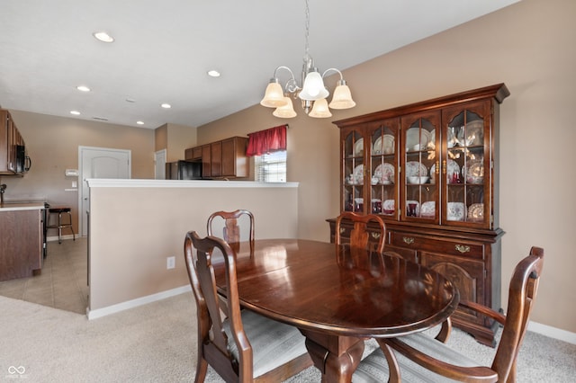 dining area featuring light colored carpet and a chandelier