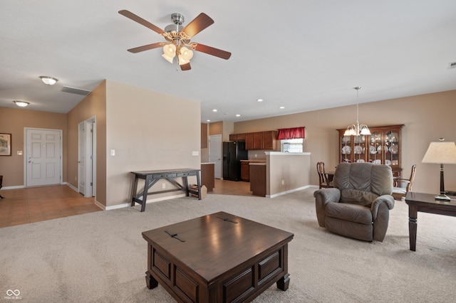 living room featuring ceiling fan with notable chandelier and light colored carpet