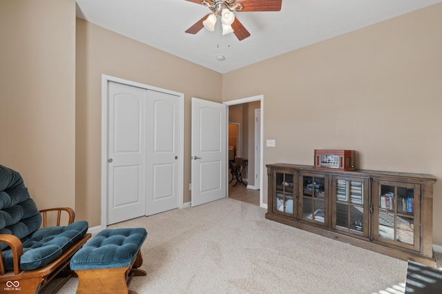 sitting room featuring light colored carpet and ceiling fan