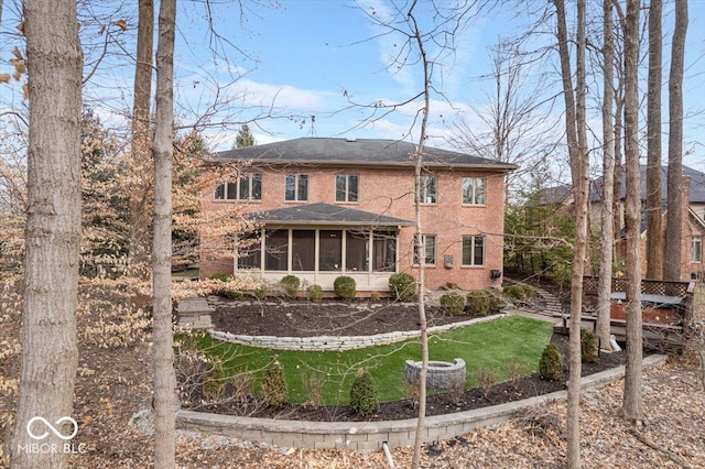 rear view of property with a sunroom and a yard