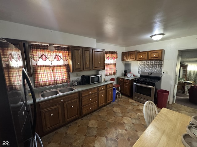 kitchen featuring backsplash, stainless steel appliances, sink, and a wealth of natural light